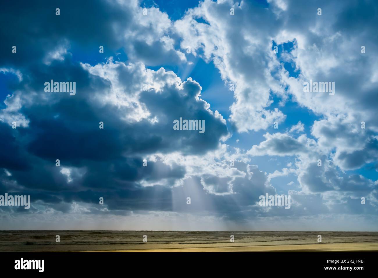 Ciel nuageux et rayons de soleil au-dessus de la mer à la plage de Bayleys à Northland, Nouvelle-Zélande. Banque D'Images