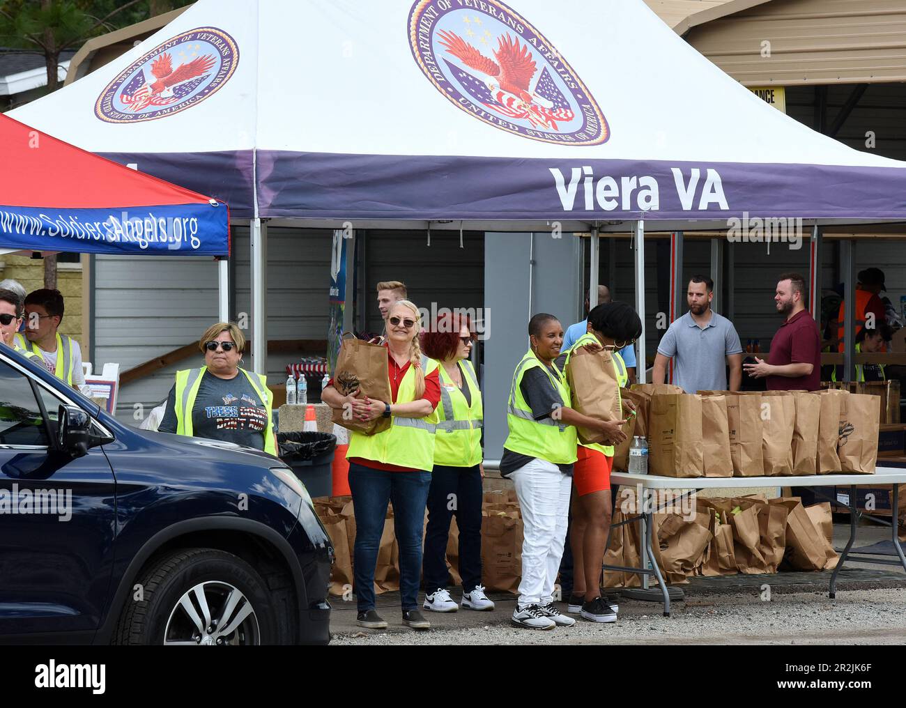 Orlando, États-Unis. 19th mai 2023. Les bénévoles placent des produits alimentaires dans des véhicules lors d'un événement de distribution alimentaire militaire et vétéran pour les personnes dans le besoin, parrainé par Lockheed Martin et l'organisme sans but lucratif national Soldiersí Angels à la Lake Baldwin va Clinic à Orlando. En reconnaissance du mois de l'appréciation militaire, 200 anciens combattants, militaires actifs, guardsmen et réservistes de la région d'Orlando ont reçu en moyenne 75 livres de fruits et légumes frais, de viandes et de denrées non périssables. Crédit : SOPA Images Limited/Alamy Live News Banque D'Images