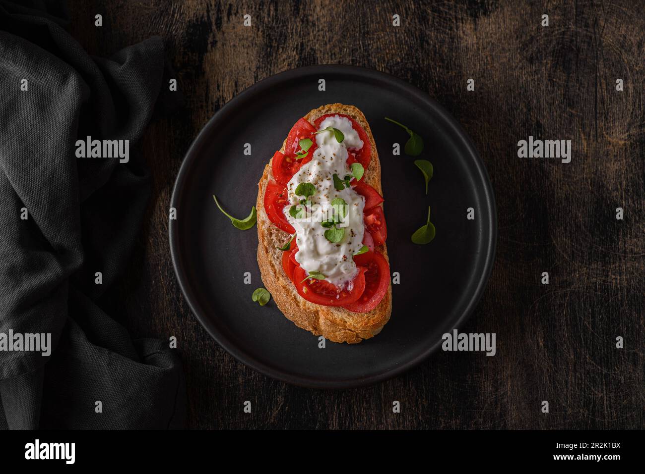 bruschetta avec tomates sur une assiette noire. Photo de haute qualité Banque D'Images