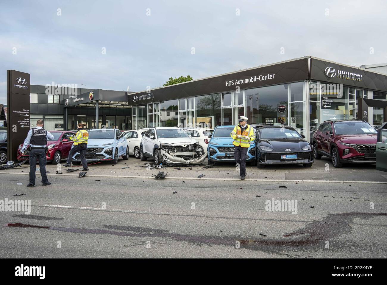 20 mai 2023, Boeblingen, Leonberg: Les policiers enregistrent les dommages devant un concessionnaire automobile. Tôt samedi matin, un accident violent s'est produit à Leonberg. Selon les rapports de la police, le conducteur d'une voiture se trouvait le long de Berliner Straße en direction du centre-ville lorsqu'il a perdu le contrôle de son véhicule dans une courbe à une vitesse manifestement excessive et s'est écrasé dans plusieurs voitures garées dans un parking d'une concession automobile. Au total, sept véhicules ont été endommagés, dont certains ont été gravement endommagés. Au moment de l'accident, le conducteur est sorti de son véhicule et a disparu. Cependant, il a pu le faire Banque D'Images