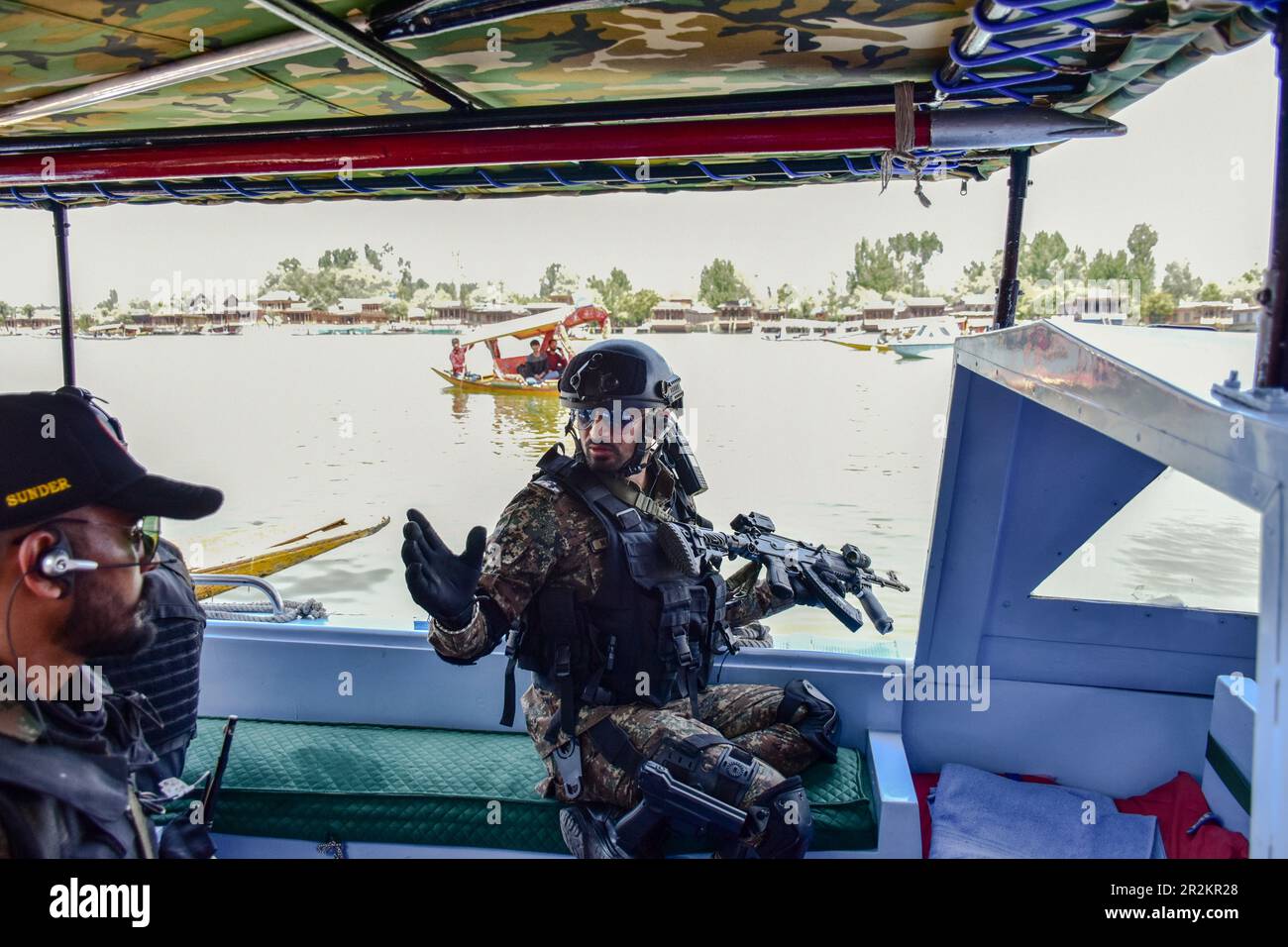 Srinagar, Inde. 20th mai 2023. Un soldat paramilitaire indien prend position dans un bateau à moteur alors qu'il patrouille sur le lac Dal avant le sommet de G20 à Srinagar. Avant le Sommet de G20, le Cachemire est sous une épaisse grille de sécurité et une sécurité à trois niveaux a été mise en place autour de SKICC et d'autres sites. De 22-24 mai, Srinagar accueillera une réunion de G20 sur le tourisme dans le cadre du Sommet 2023 de G20. Crédit : SOPA Images Limited/Alamy Live News Banque D'Images