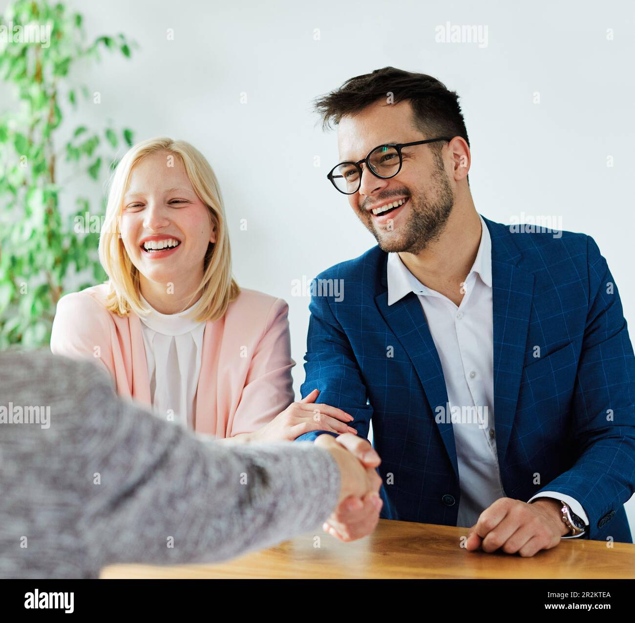 un jeune couple qui tremble les mains traite contrat d'investissement immobilier agent d'accord d'affaires poignée de main signature Banque D'Images