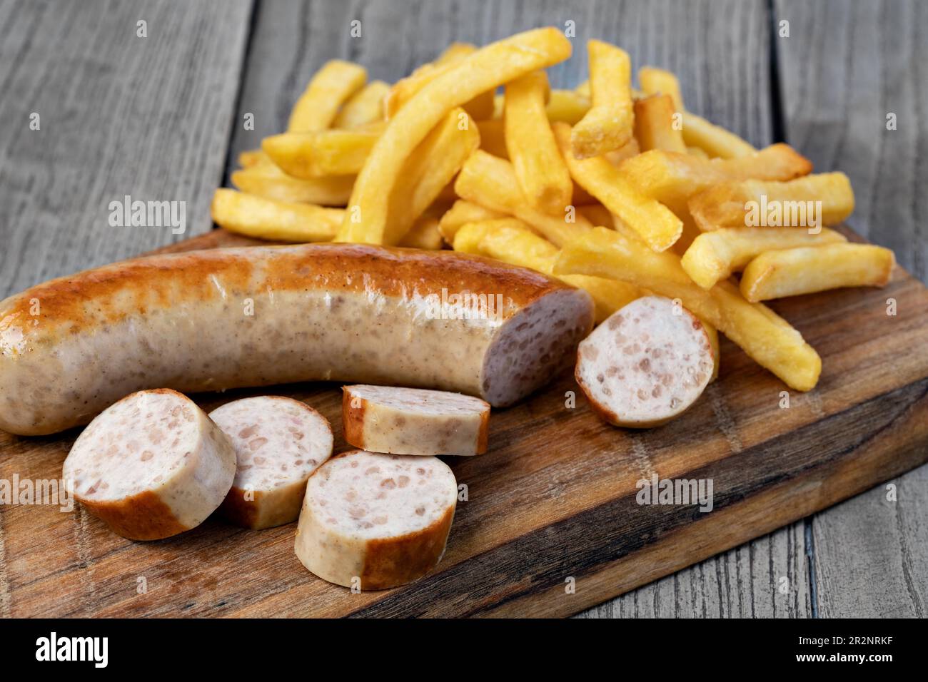 Saucisse allemande et de pommes de terre frite sur un sol en bois Banque D'Images