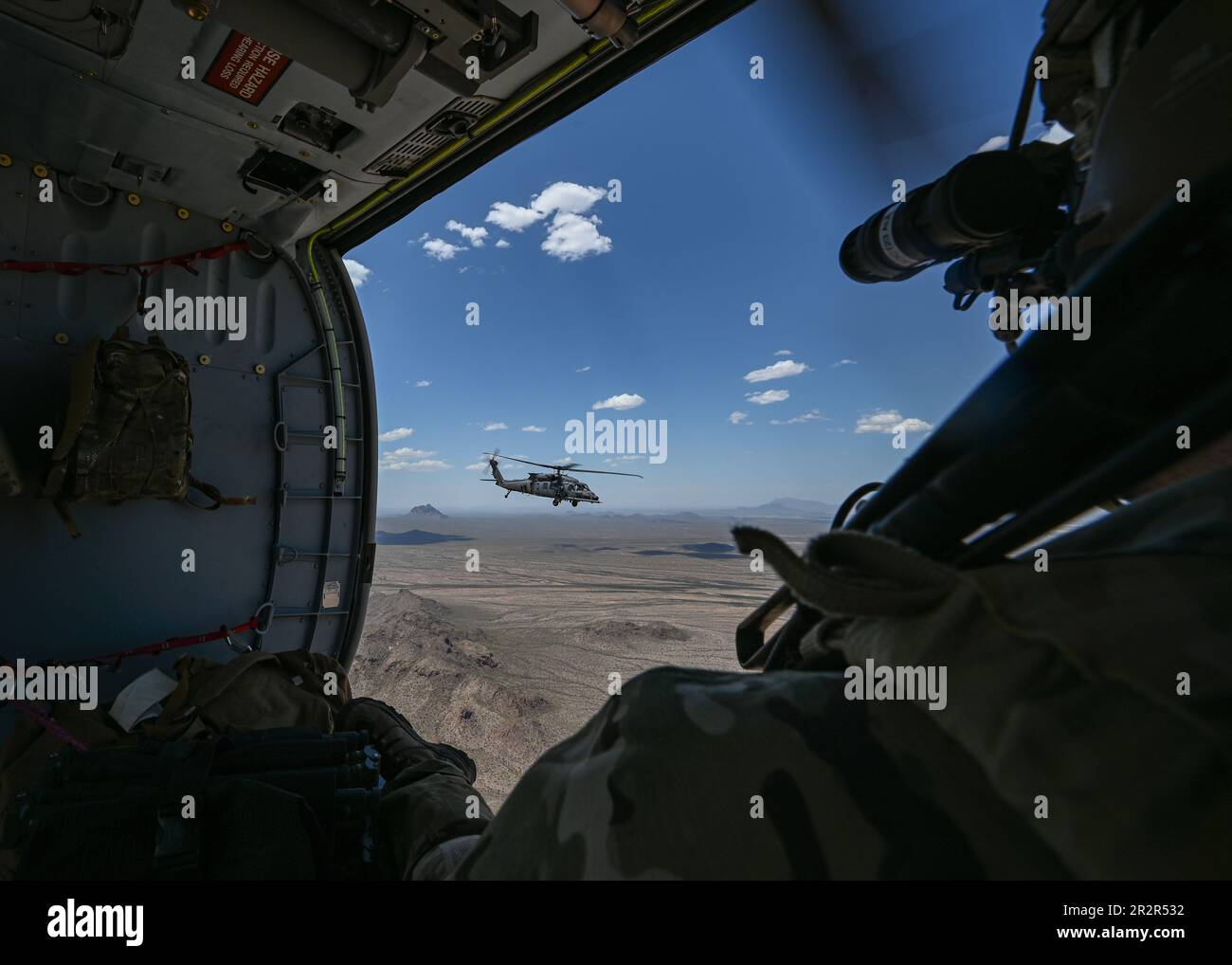 A ÉTATS-UNIS Air Force Airman regarde un hélicoptère HH-60W Jolly Green II, affecté à la base aérienne de Kirtland, au Nouveau-Mexique, voler pendant LE RED FLAG-Rescue 23-1 au-dessus de l'Arizona, au 13 mai 2023. Au cours de cette itération de RF-R, des aviateurs de partout au pays, ainsi que des Marines, des soldats et des marins ont travaillé ensemble pour effectuer de multiples exercices d'entraînement et établir des relations de force conjointe. (É.-U. Photo de la Force aérienne par Airman classe 1st Paige Weldon) Banque D'Images