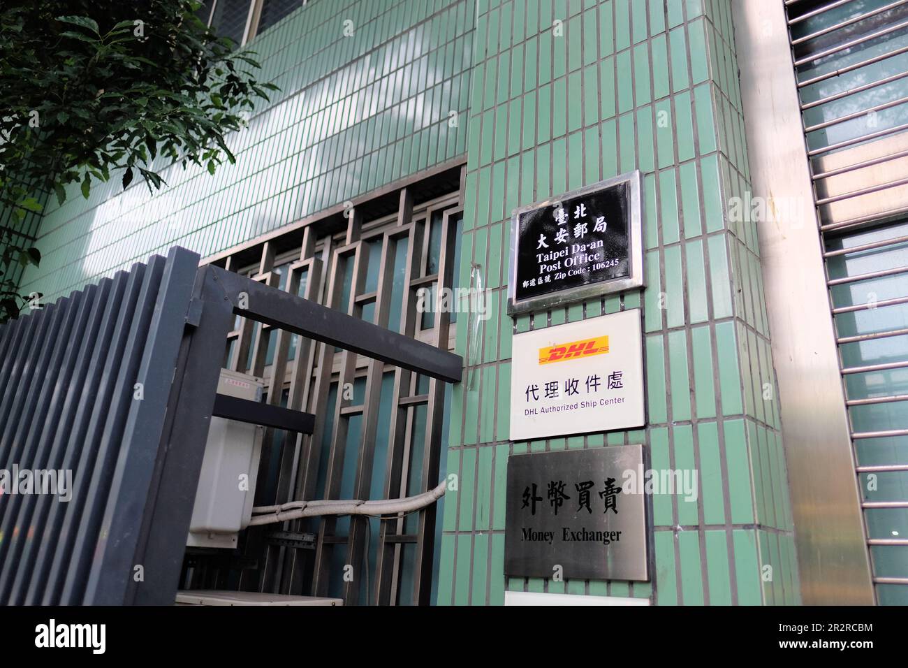 Panneau à l'entrée du bureau de poste de Taipei Da'an à Taïwan, code postal 106245; centre d'expédition agréé DHL et services d'échange de monnaie. Banque D'Images