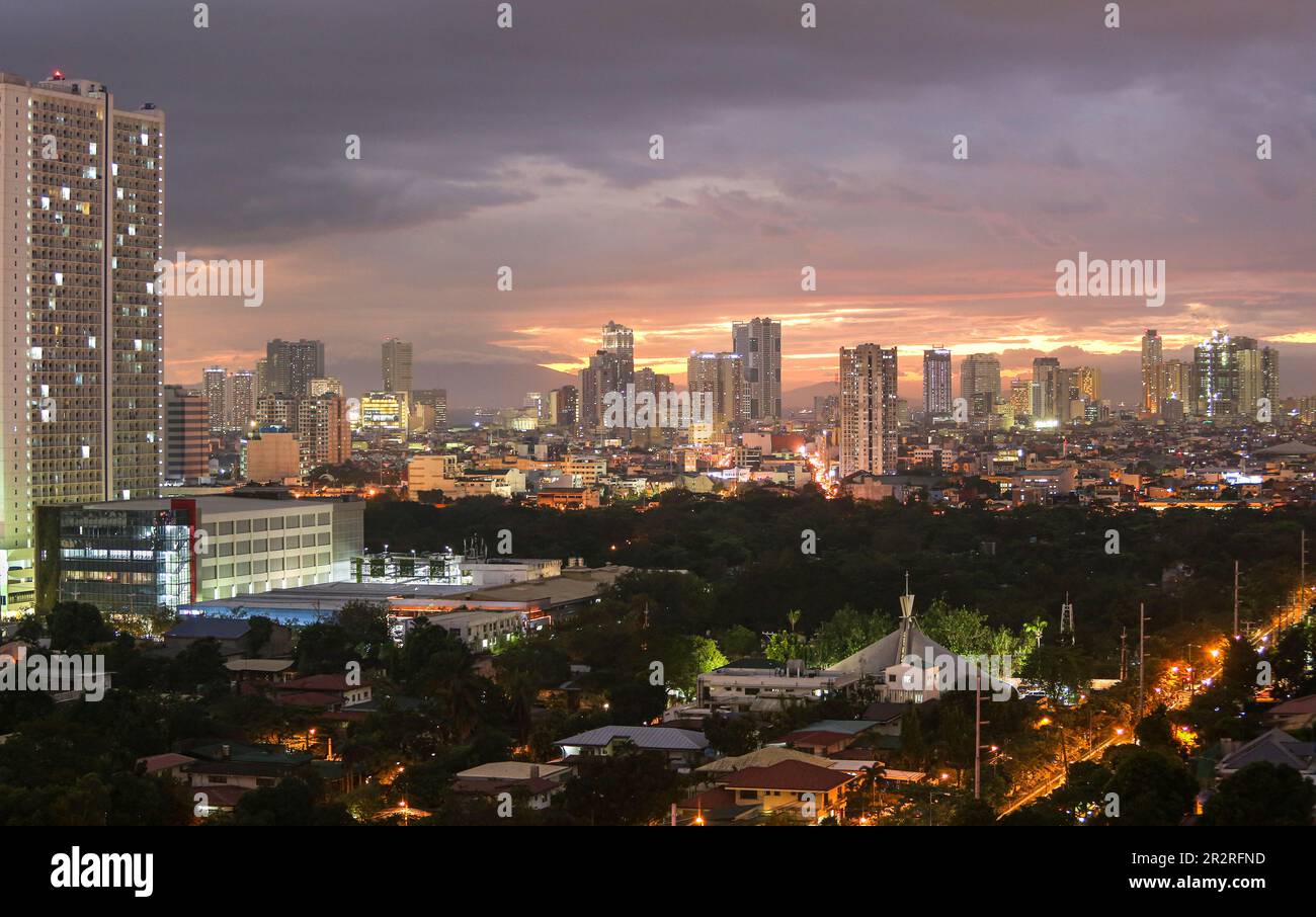 Coucher de soleil sur Manille Skyline & Bay vu du bâtiment de la ville de Makati, ciel rose nuageux, paysage urbain, cimetière sud de Manille, capitale des Philippines Banque D'Images