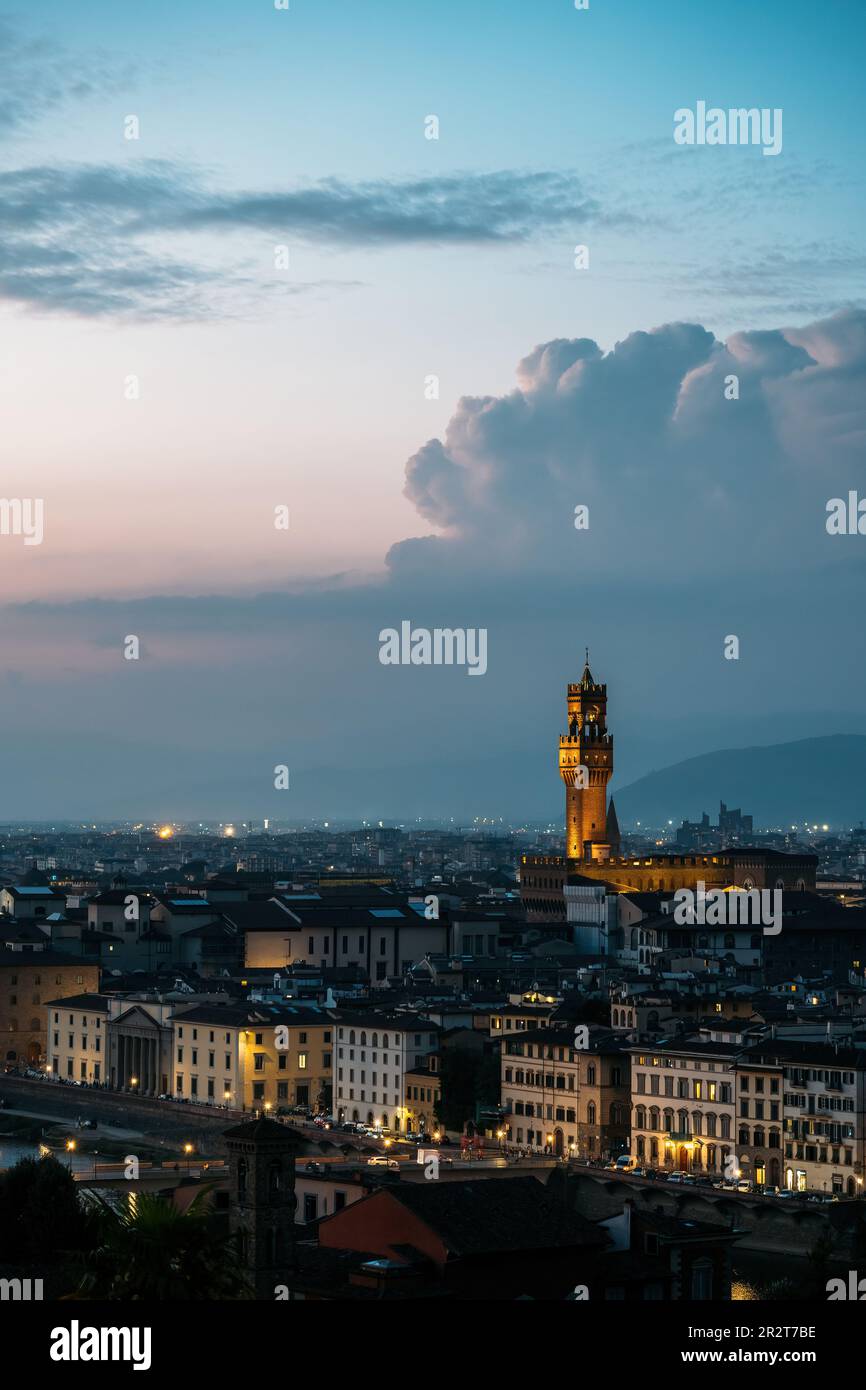 Vue verticale du Vieux Palais à Florence l'architecte de la tour de l'hôtel de ville Arnolfo di Cambio dans les lumières du soir, l'été chaud avec de superbes cumulus nuages Banque D'Images