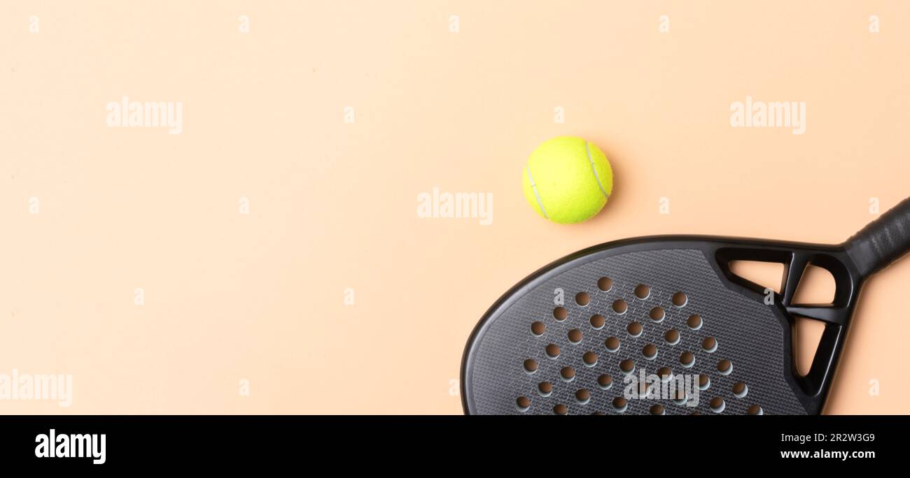Paddle de tennis professionnelle noire et balle sur fond beige. Affiche sur le thème du sport horizontal, cartes de vœux, en-têtes, site Web et application Banque D'Images