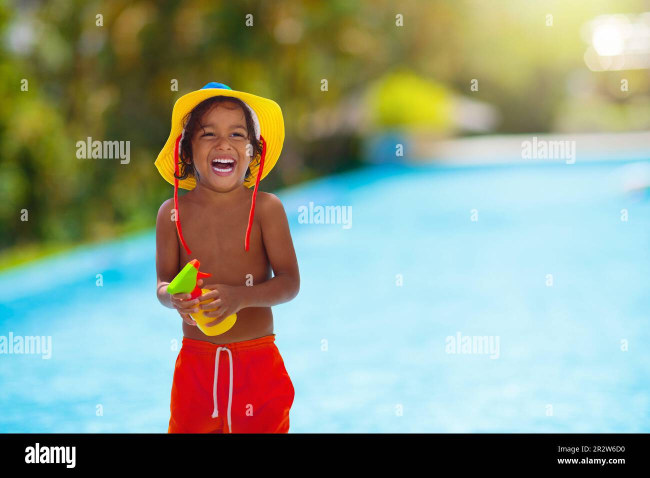 Enfant avec crème solaire à la piscine. Crème solaire pour un bronzage  sain. Un divertissement sûr en été. Jeux pour enfants. Protection UV et  soin de la peau. Petit garçon sur la