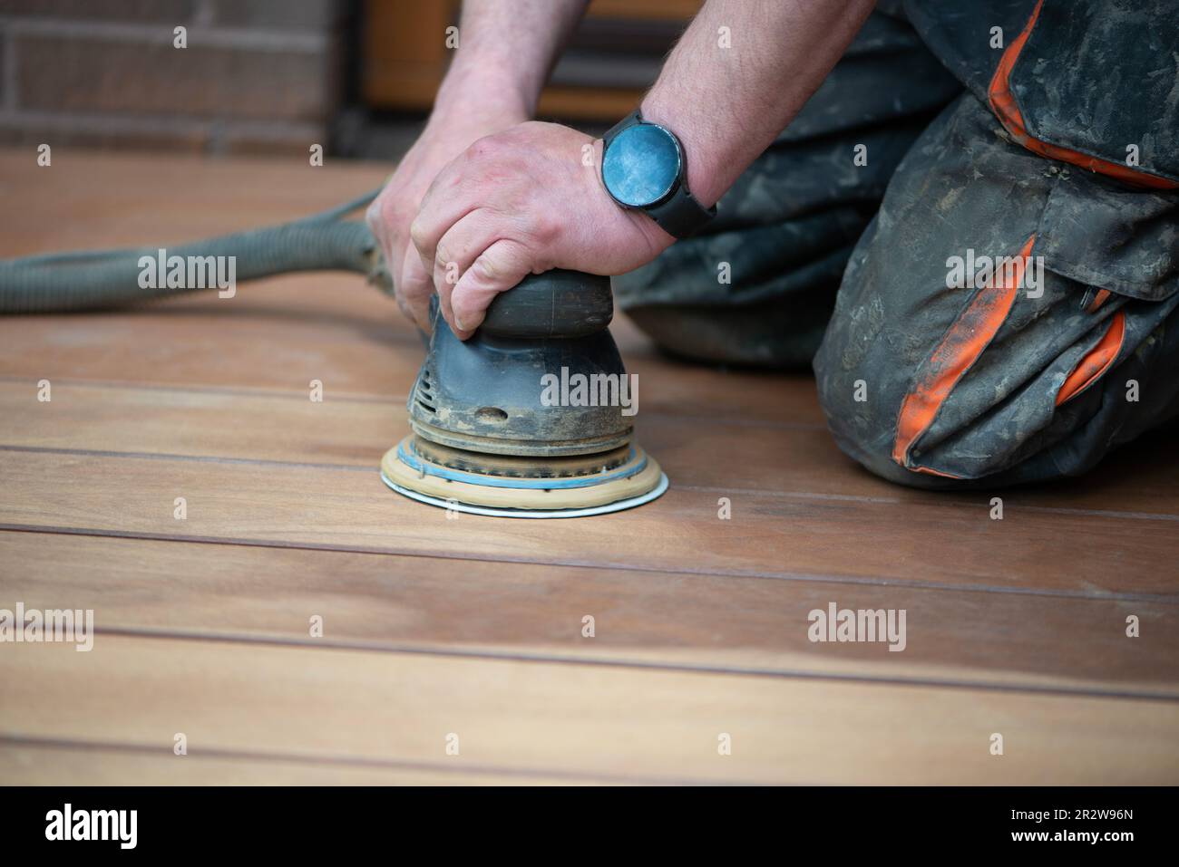 Procédé de ponçage des planchers de terrasse en bois. La ponceuse élimine les imperfections. Banque D'Images