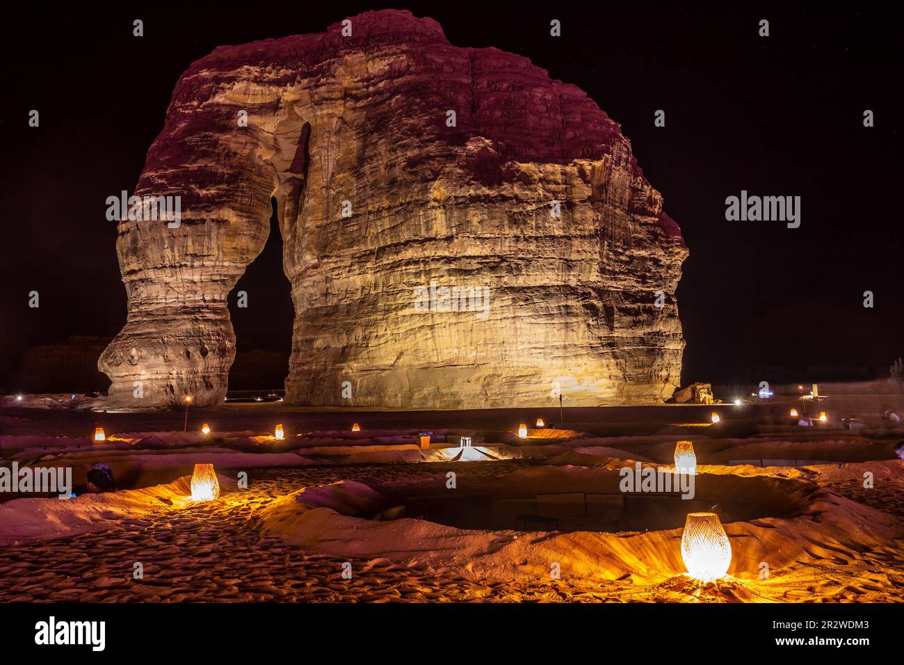 Salon extérieur éclairé en face du monolithe d'érosion des rochers d'éléphant, debout dans le désert de nuit, Al Ula, Arabie Saoudite Banque D'Images