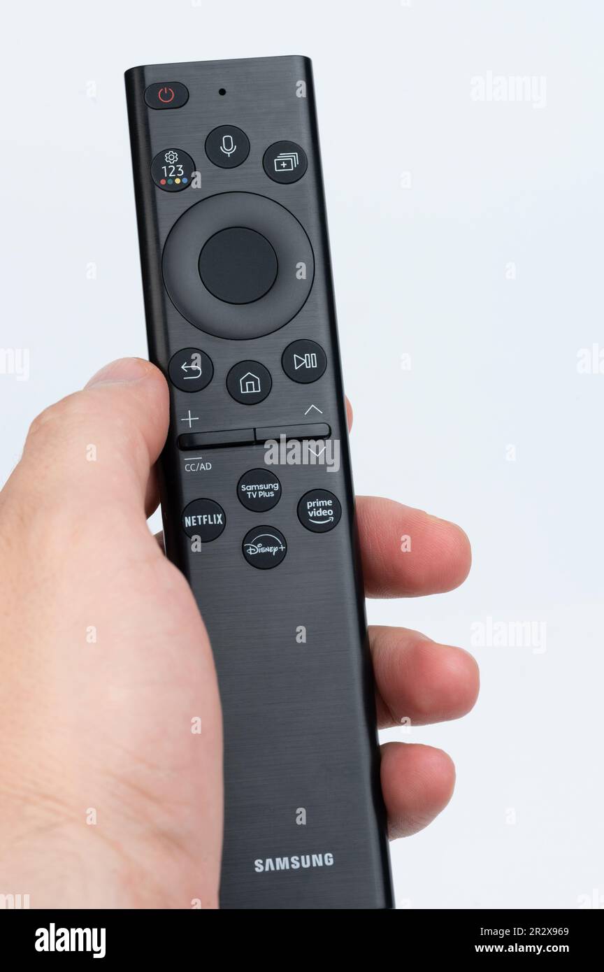 New york, Etats-Unis - 14 mai 2023: Samsung Remote contol en main avec netflix, disney , vidéo de premier plan sur l'arrière-plan de studio Banque D'Images