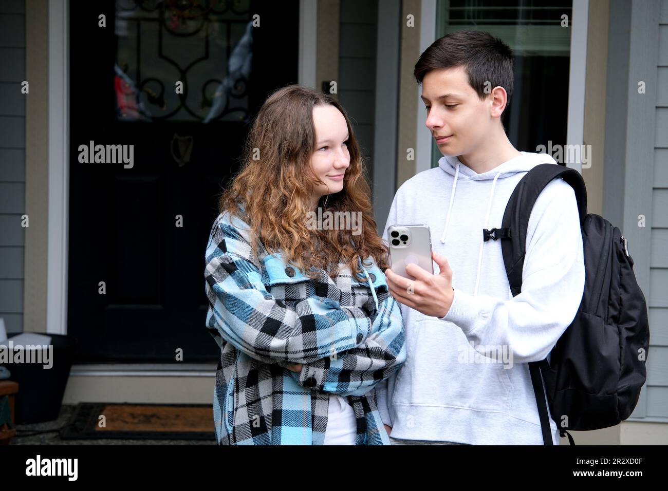 lycéens amis lycéens voir hors de la maison de fille aller ensemble aider à porter porte-documents amis parler passer du temps avec la petite amie première date écraser la relation premier amour regarder tendinement Banque D'Images