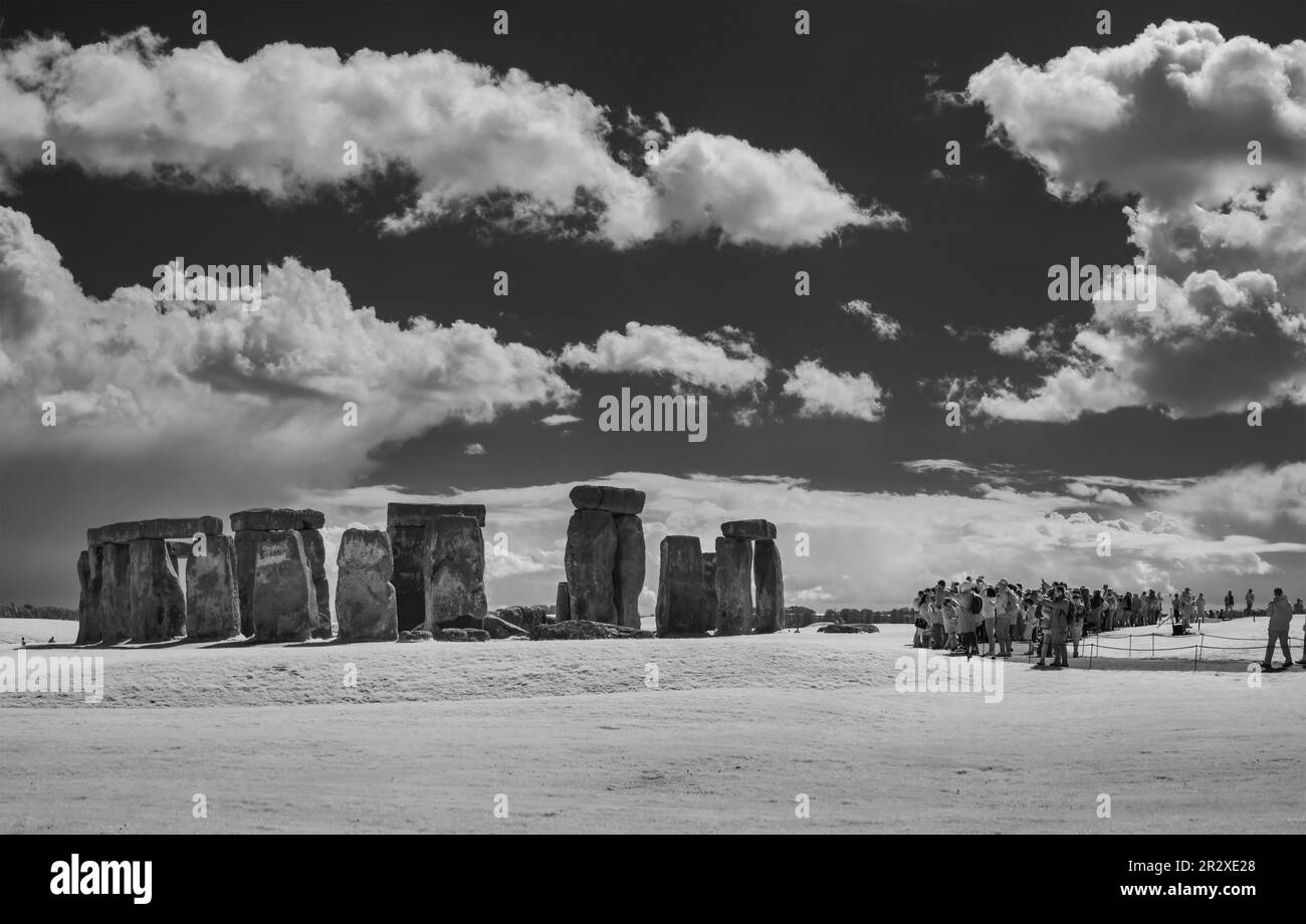 STONEHENGE, WILTSHIRE, ANGLETERRE - 13th AVRIL 2023 : foule de touristes visitant l'ancien anneau de pierre debout de Stonehenge, image infrarouge monochrome. Banque D'Images