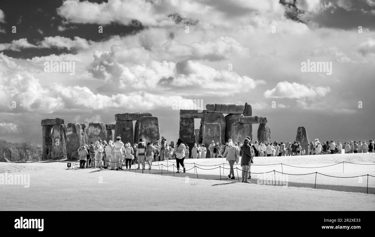 STONEHENGE, WILTSHIRE, ANGLETERRE - 13th AVRIL 2023 : foule de touristes visitant l'ancien anneau de pierre debout de Stonehenge, image infrarouge monochrome. Banque D'Images