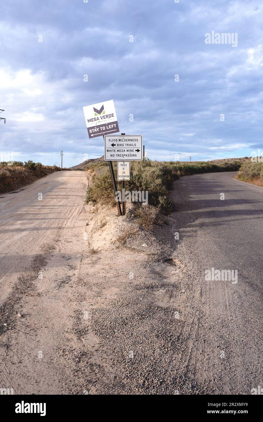 Une route se divise en deux, des panneaux indiquent Mesa Verde, Ojito Wilderness Bike Trails et White Mesa Mine. Un autre panneau indique Pueblo de Zia Reservation. Banque D'Images