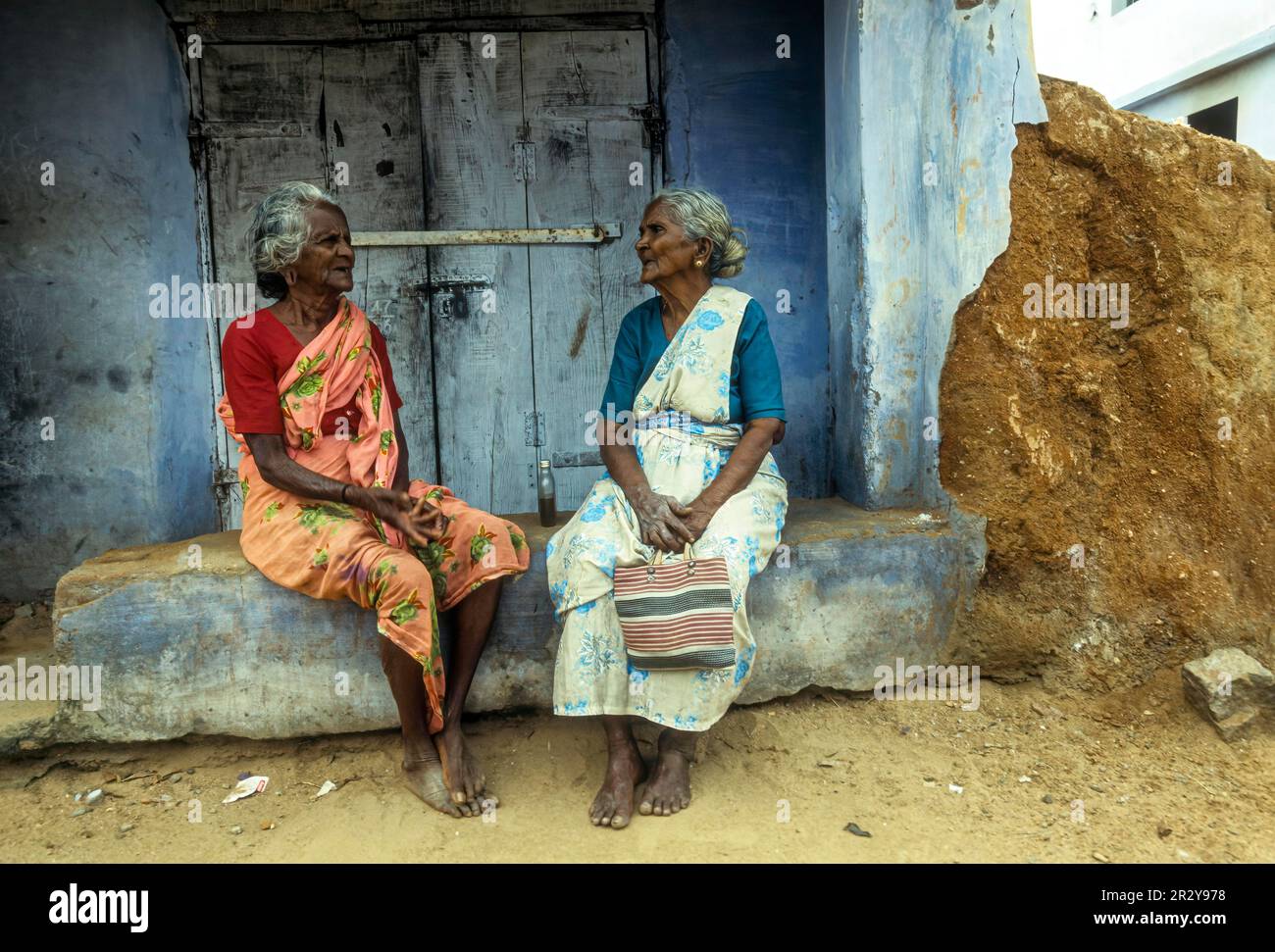 Deux vieilles femmes qui se chainent devant un magasin fermé à Courtalam Kutralam Kuttalam, Tamil Nadu, Inde du Sud, Inde, Asie Banque D'Images