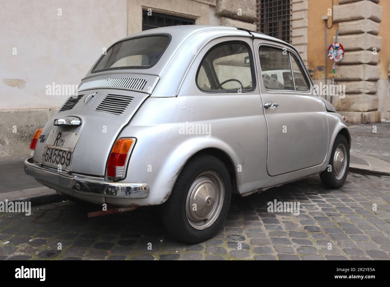 Fiat 500 dans un état de bataille marqué à la conduite des rues de Rome pendant des années. Malgré les bulles de peinture et les bosses visibles, il reste un survivant. Banque D'Images
