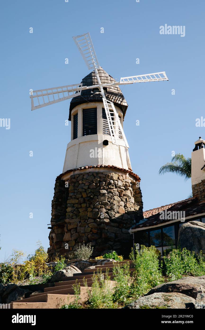 Moulin avec ancien château de roche. toit en carreaux rouges et guirlande de lumières. Moulin à vent moderne. Campagne par une belle journée d'été Banque D'Images