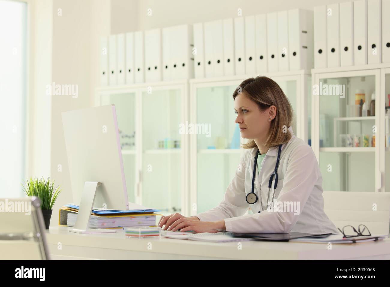 Le travailleur dans le domaine de la médecine saisit les données patient sur ordinateur Banque D'Images