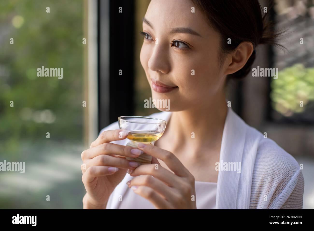 Élégante jeune femme chinoise qui boit du thé dans le salon de thé Banque D'Images