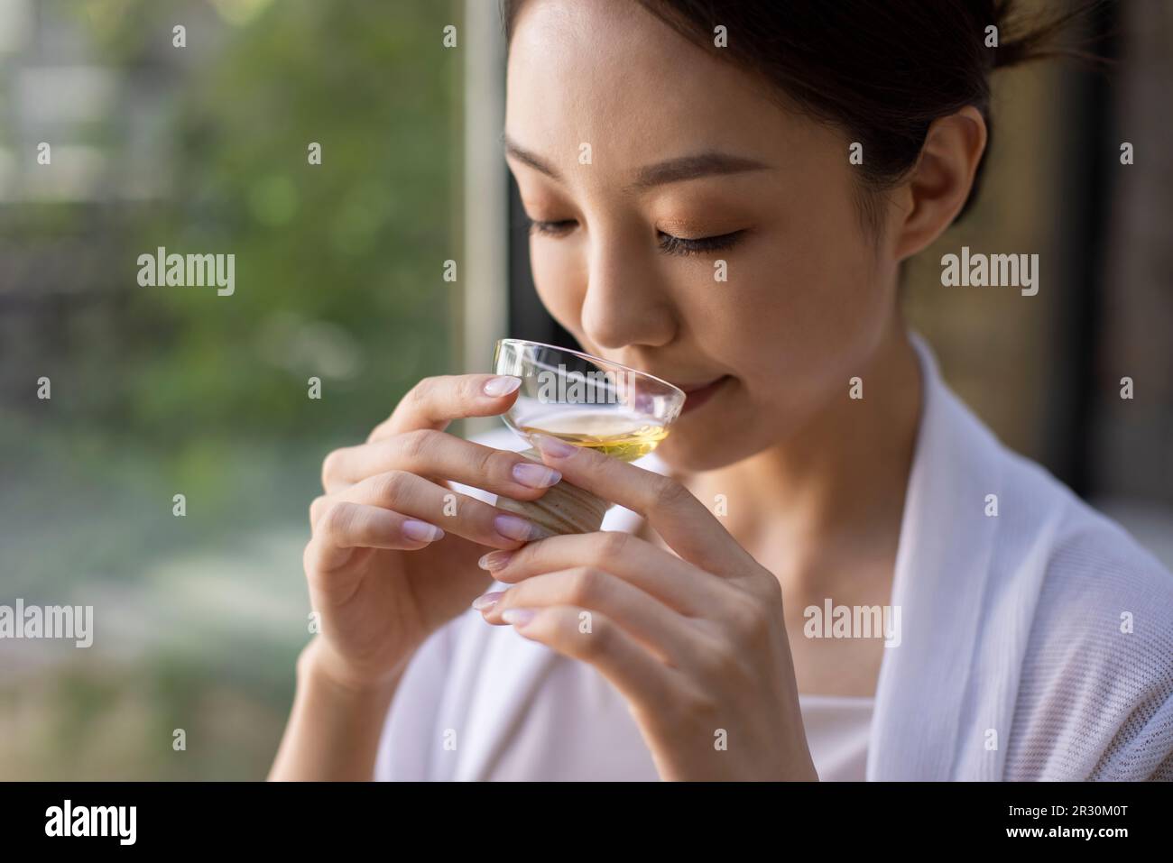 Élégante jeune femme chinoise qui boit du thé dans le salon de thé Banque D'Images