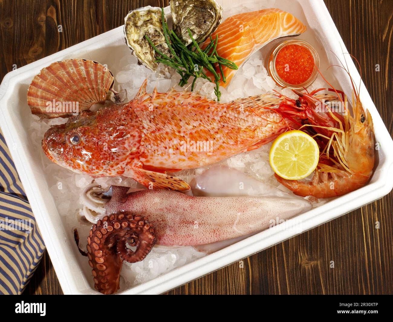 Boîte de transport avec poisson, fruits de mer et glace sur fond en bois Banque D'Images