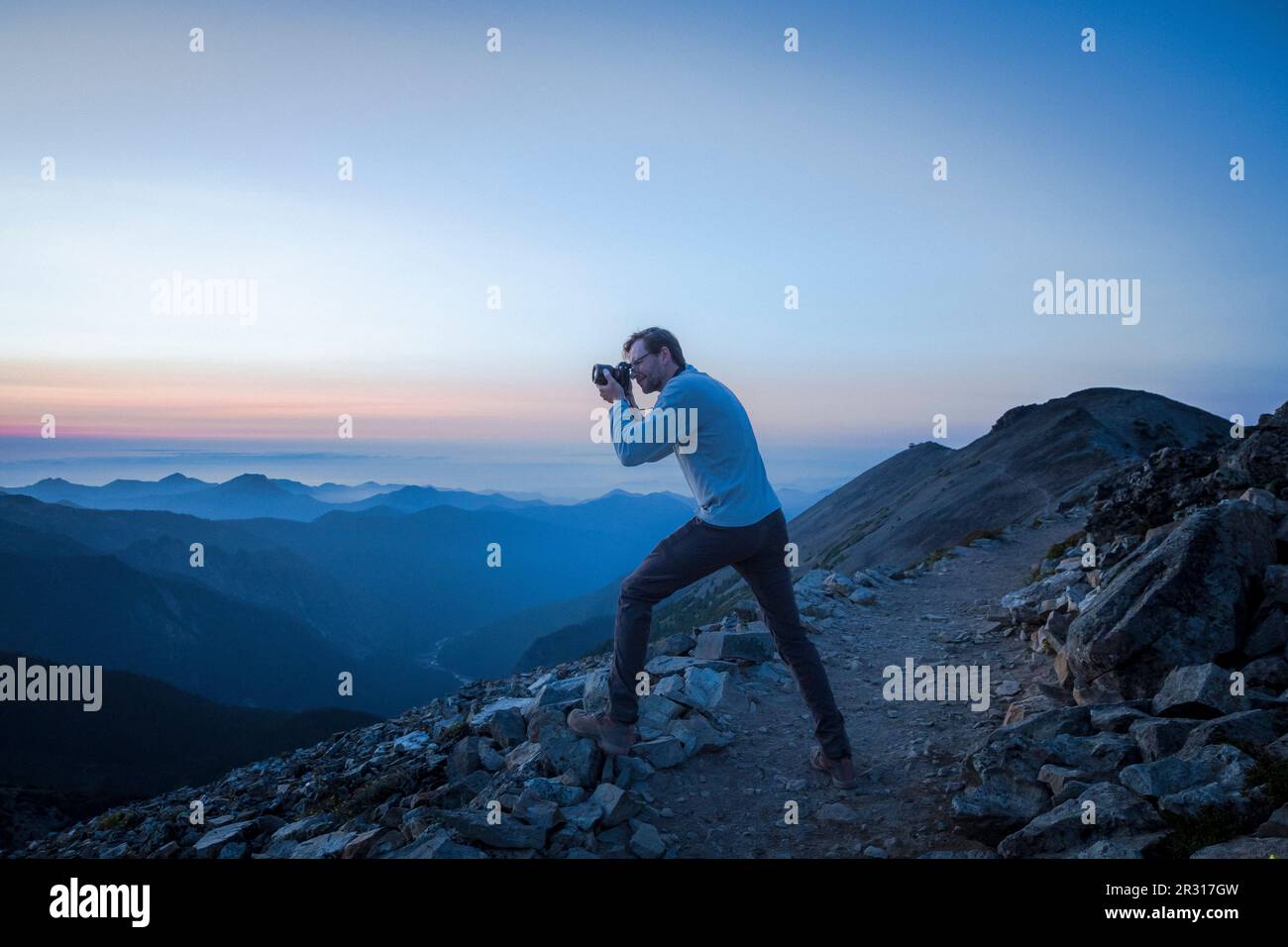 Un homme prend des photos des montagnes du soir à Mt. Parc national Rainier Banque D'Images
