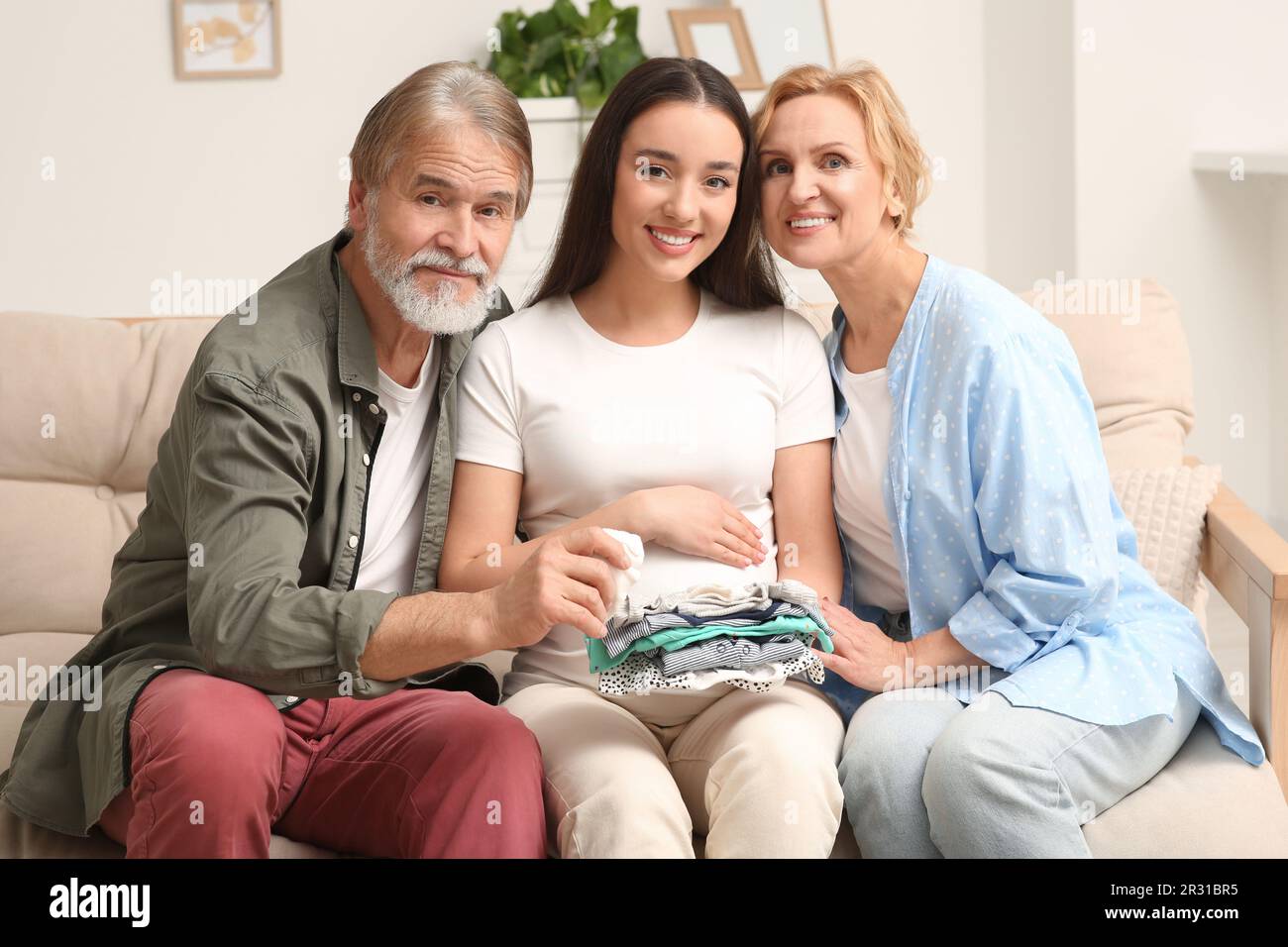 Une femme enceinte heureuse qui passe du temps avec ses parents à la maison. Réaction des grands-parents à l'avenir de leur petit-fils Banque D'Images