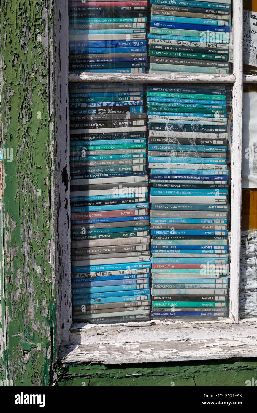 Les manuels d'atelier des voitures anciennes et décolorées sont empilés dans une fenêtre d'atelier. Salisbury 2023. Banque D'Images