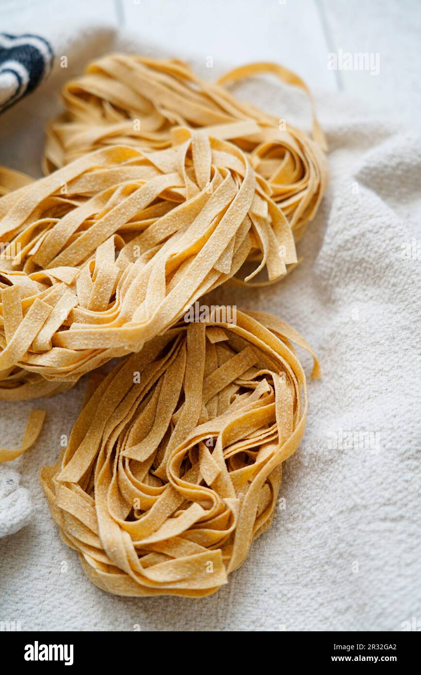Tagliatelle de blé entier non cuite sur fond de bois blanc, Italie, Europe Banque D'Images