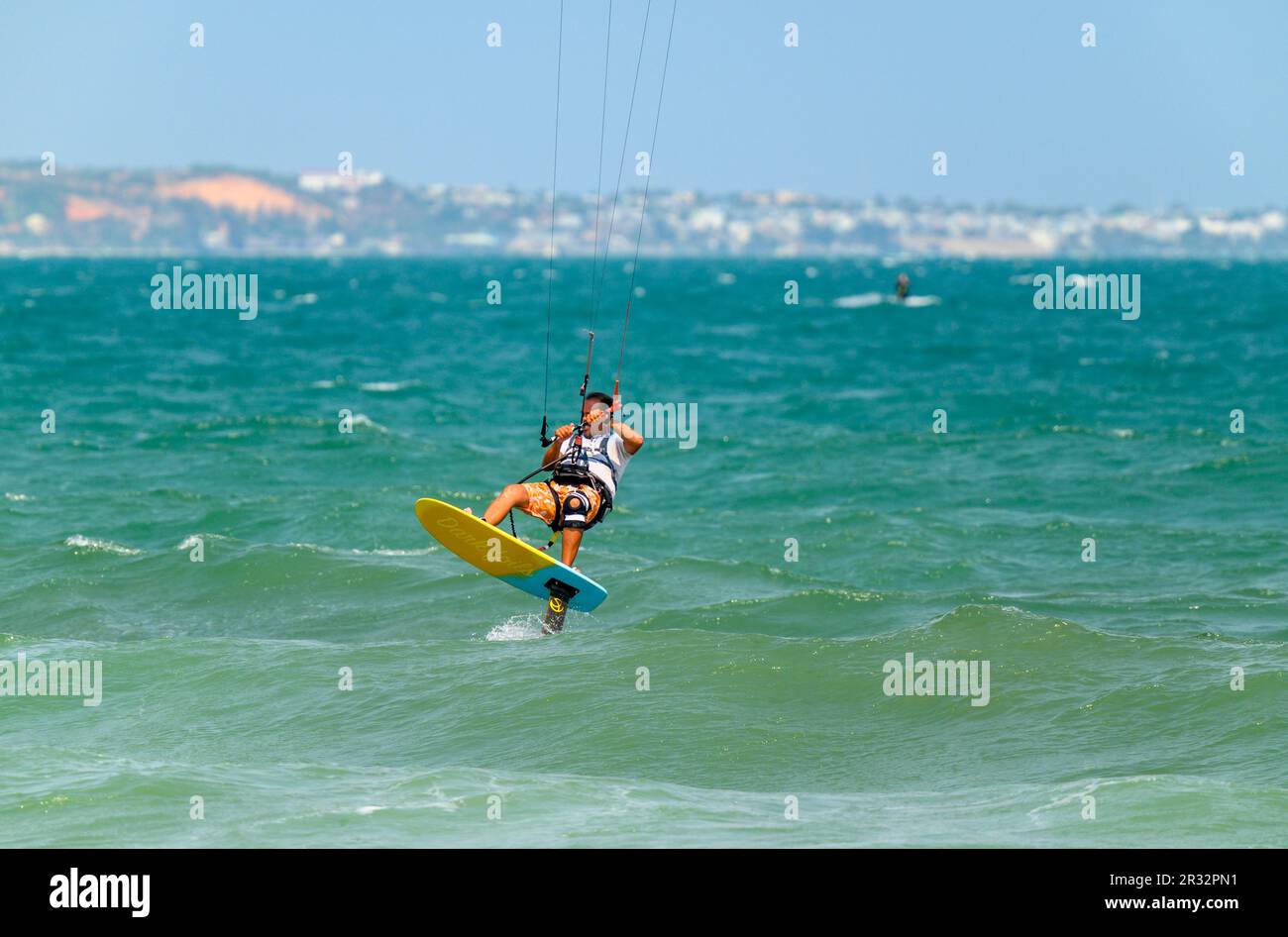 Un kitesurfer passe son hydroptère au large de la plage de Mui ne, Vietnam. Banque D'Images