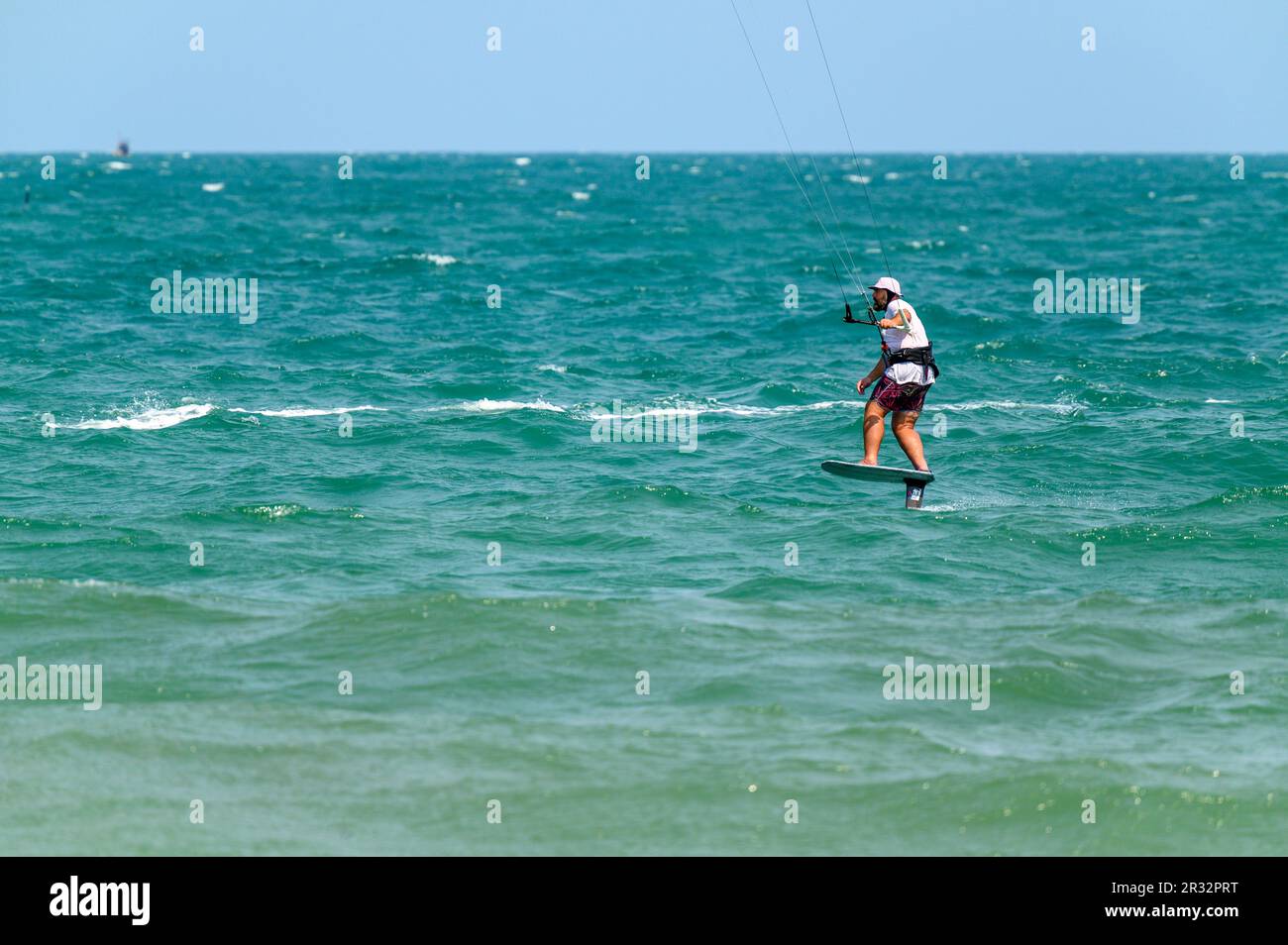 Un kitesurfer passe son hydroptère au large de la plage de Mui ne, Vietnam. Banque D'Images