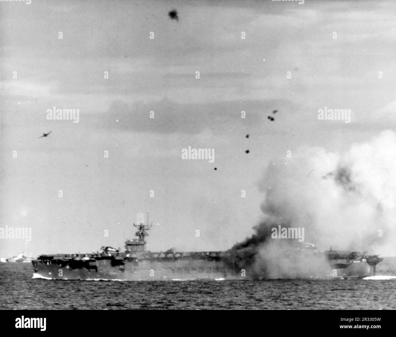 Un avion-suicide japonais Mitsubishi A6M kamikaze frappe les États-Unis Le transporteur d'escorte de la Marine USS Suwannee (CVE-27) le 25 octobre 1944. Notez que le Grumman F6F Hellcat termine l'arrachement après avoir chassant l'avion kamikaze. Lorsque le Japon était confronté à la défaite de fin 1944, il a choisi de détruire des navires américains par des attentats-suicides, connus sous le nom de Kamikaze.ces attaques étaient une arme physique et psychologique puissante et ont coulé un total de 47 navires pour un coût de plus de 3000 pilotes et avions. À la fin de 1944, la marine américaine était suffisamment importante pour que les pertes soient insignifiantes et qu’elles n’aient pas modifié le cours de la guerre. Banque D'Images