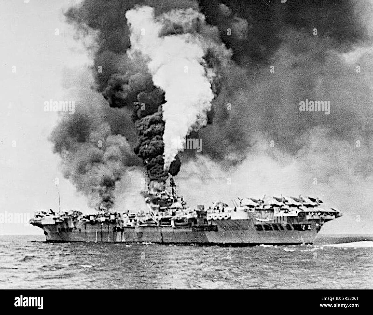 Le porte-avions HMS formidable (R67) en feu après avoir été frappé par un kamikaze au large de Sakishima Gunto. Formidable a été frappé à 1130 heures, le kamikaze faisant une bosselure massive d'environ 3 m de long, 0,6 m de large et de profondeur dans le pont de vol blindé. Une grande trappe en acier s'est envolée à travers le pont du hangar et la chaufferie centrale, où elle a rompu une ligne de vapeur, et est venue se reposer dans un réservoir de carburant, ce qui a déclenché un incendie majeur dans le parc de l'avion. Huit membres d'équipage ont été tués et quarante-sept ont été blessés. Un Corsair de Vought et dix Avengers de Grumman ont été détruits Banque D'Images