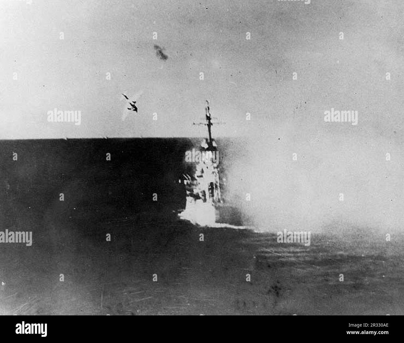 Un avion japonais Kamikaze plongée sur les États-Unis Navire de croisière léger USS Columbia (CL-56) à 1729 heures le 6 janvier 1945, pendant l'opération du golfe de Lingayen. Cet avion a heurté le pont principal par la tourelle de l'après-canon, causant des dommages importants et des pertes. L'avion et sa bombe ont pénétré deux ponts avant d'exploser, tuant 13 personnes et blessant 44 personnes. Lorsque le Japon était confronté à la défaite de fin 1944, il a choisi de détruire des navires américains par des attentats-suicides, connus sous le nom de Kamikaze.ces attaques étaient une arme physique et psychologique puissante et ont coulé un total de 47 navires pour un coût de plus de 3000 pilotes et avions. Vers la fin de 19 Banque D'Images