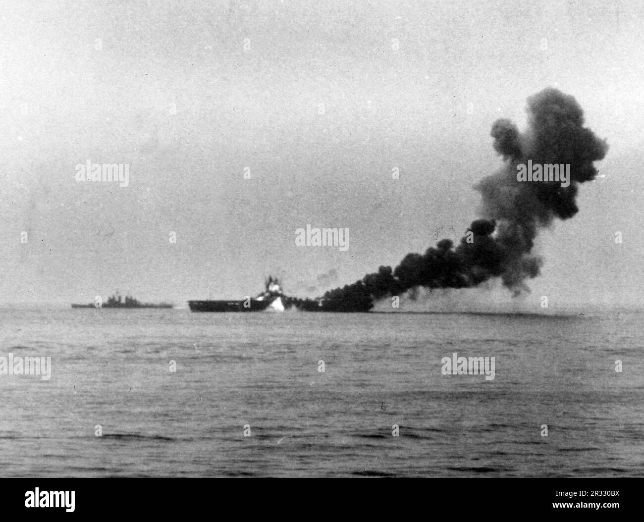 Un deuxième kamikaze japonais, un Mitsubishi A6M Zero piloté par Ensign Kiyoshi Ogawa, frappe les États-Unis Porte-avions USS Bunker Hill (CV-17) de la Marine, environ 1005 heures, 11 mai 1945. Le navire est déjà en train de brûler à partir d'une grève kamikaze 30 secondes plus tôt. La grève a pris des avions entièrement alimentés et armés sur le pont et a déclenché des feux très dangereux. Bien que fortement endommagé, le navire ne s'est pas effondré et est retourné aux États-Unis pour réparation. Le navire a été mis hors service en 1966 et mis au rebut en 1973. Banque D'Images