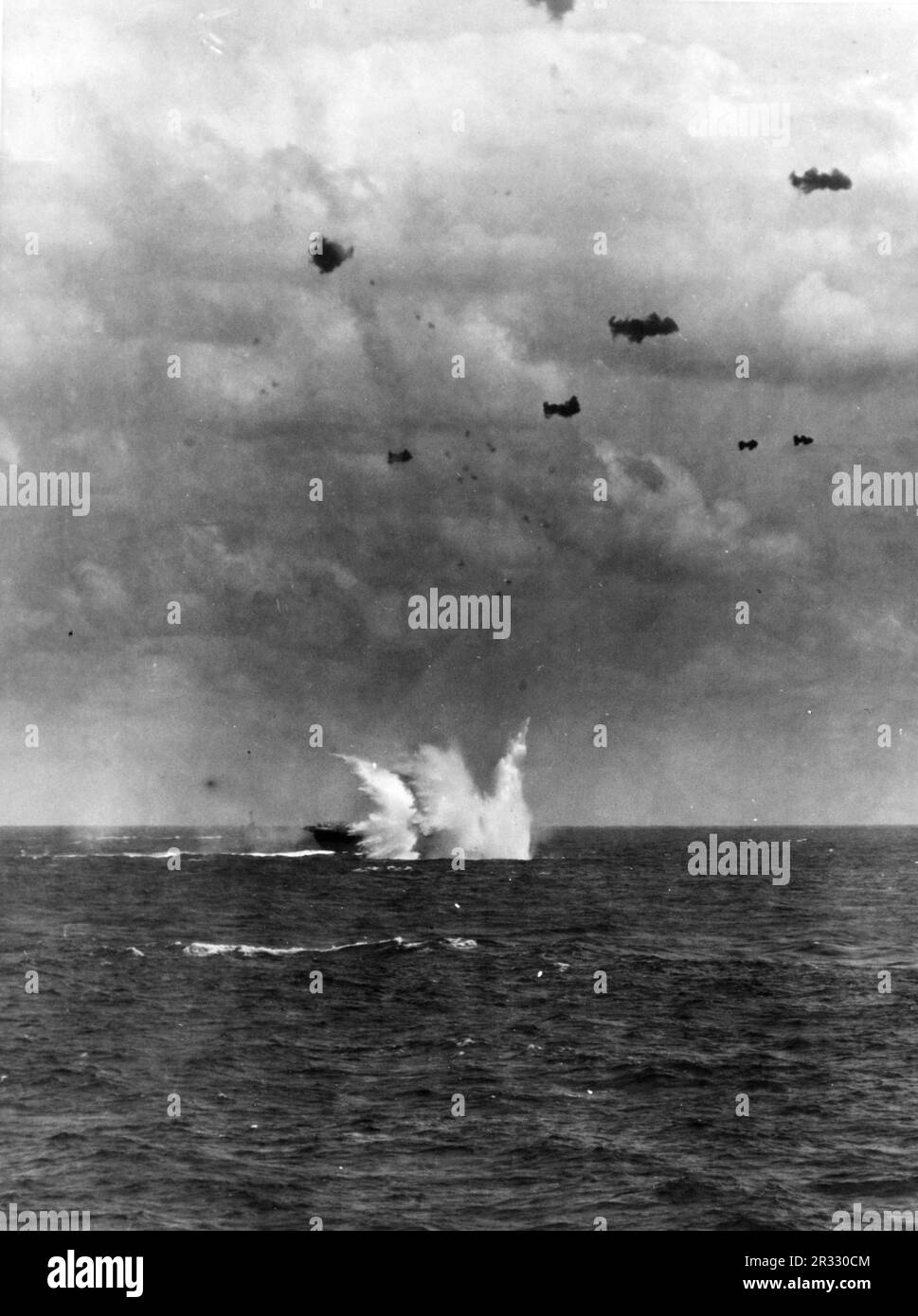 Un avion kamikaze frappe l'eau au large du quartier tribord des États-Unis Le porte-avions de la Marine USS Enterprise (CV-6), pendant les opérations au large d'Okinawa, le 11 avril 1945. Lorsque le Japon était confronté à la défaite de fin 1944, il a choisi de détruire des navires américains par des attentats-suicides, connus sous le nom de Kamikaze.ces attaques étaient une arme physique et psychologique puissante et ont coulé un total de 47 navires pour un coût de plus de 3000 pilotes et avions. À la fin de 1944, la marine américaine était suffisamment importante pour que les pertes soient insignifiantes et qu’elles n’aient pas modifié le cours de la guerre. Banque D'Images