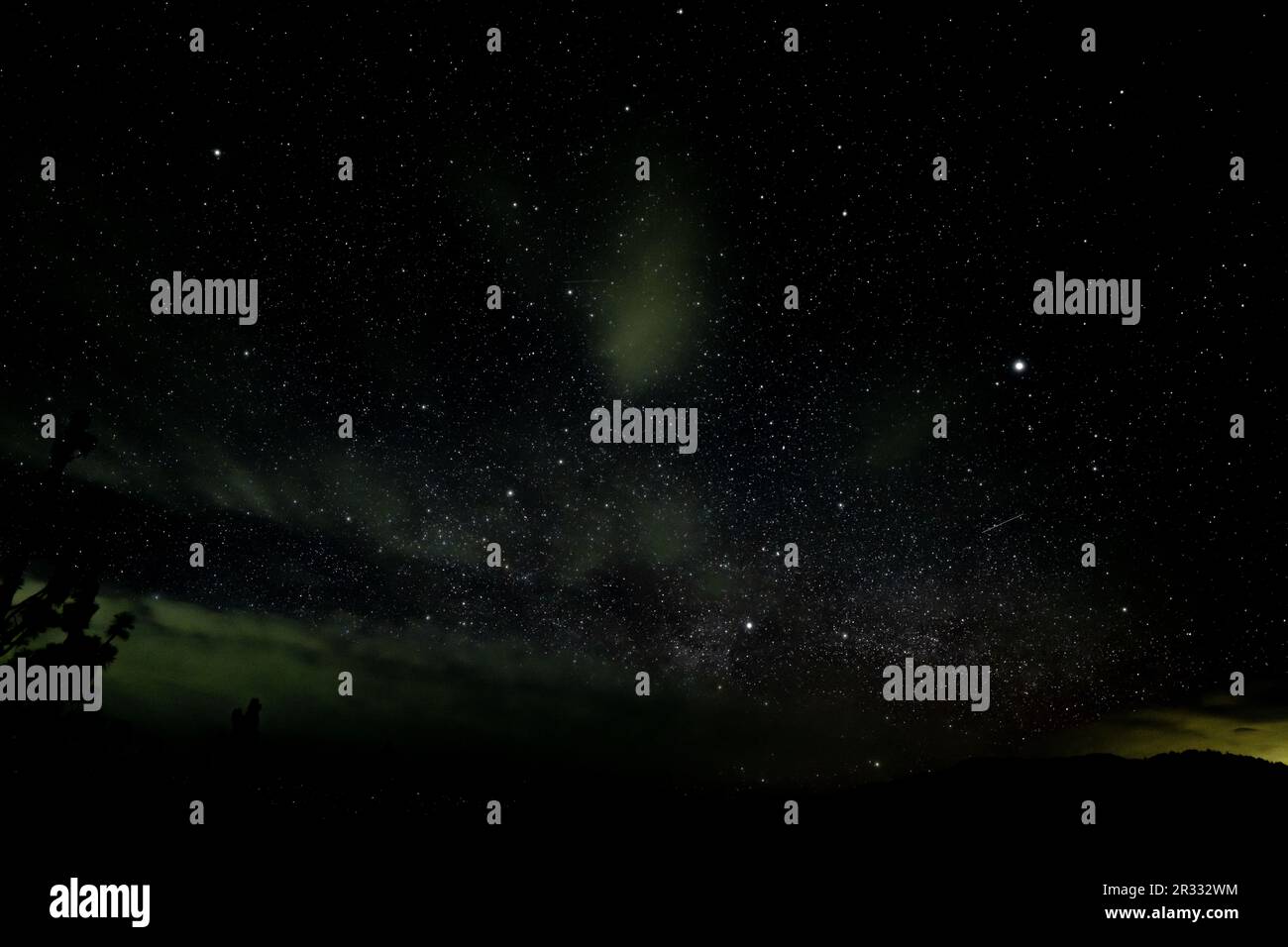 Une boule de feu de météore fille ciel tandis qu'aurora illumine les nuages avec la voie lactée au-dessus de l'horizon. L'image a été prise près d'Ashland, OREGON. 8 secondes Banque D'Images