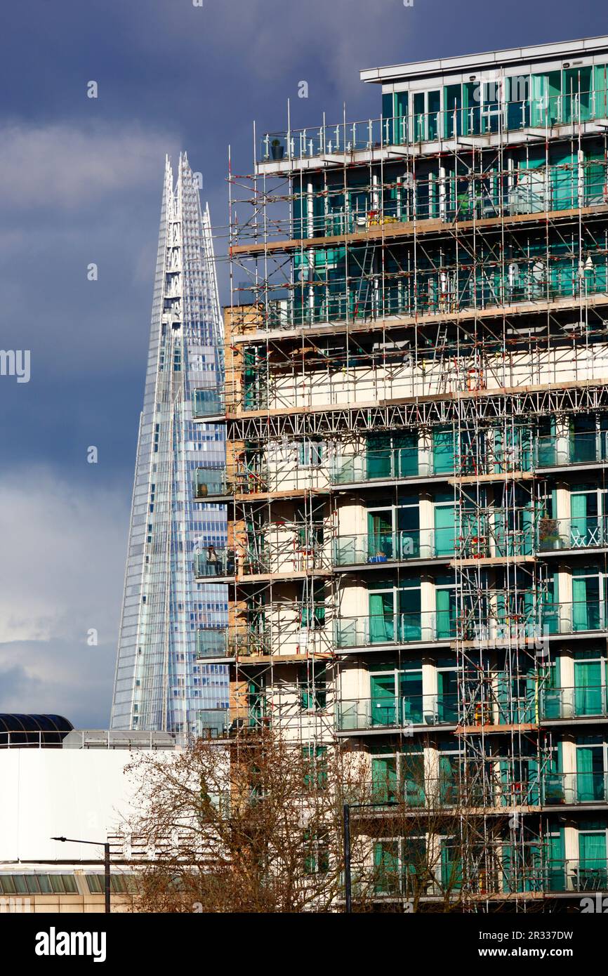 Personnes assises sur le balcon d'un nouvel immeuble d'appartements sur le Albert Embankment, la tour Shard en arrière-plan sous un ciel orageux, Londres, Royaume-Uni Banque D'Images