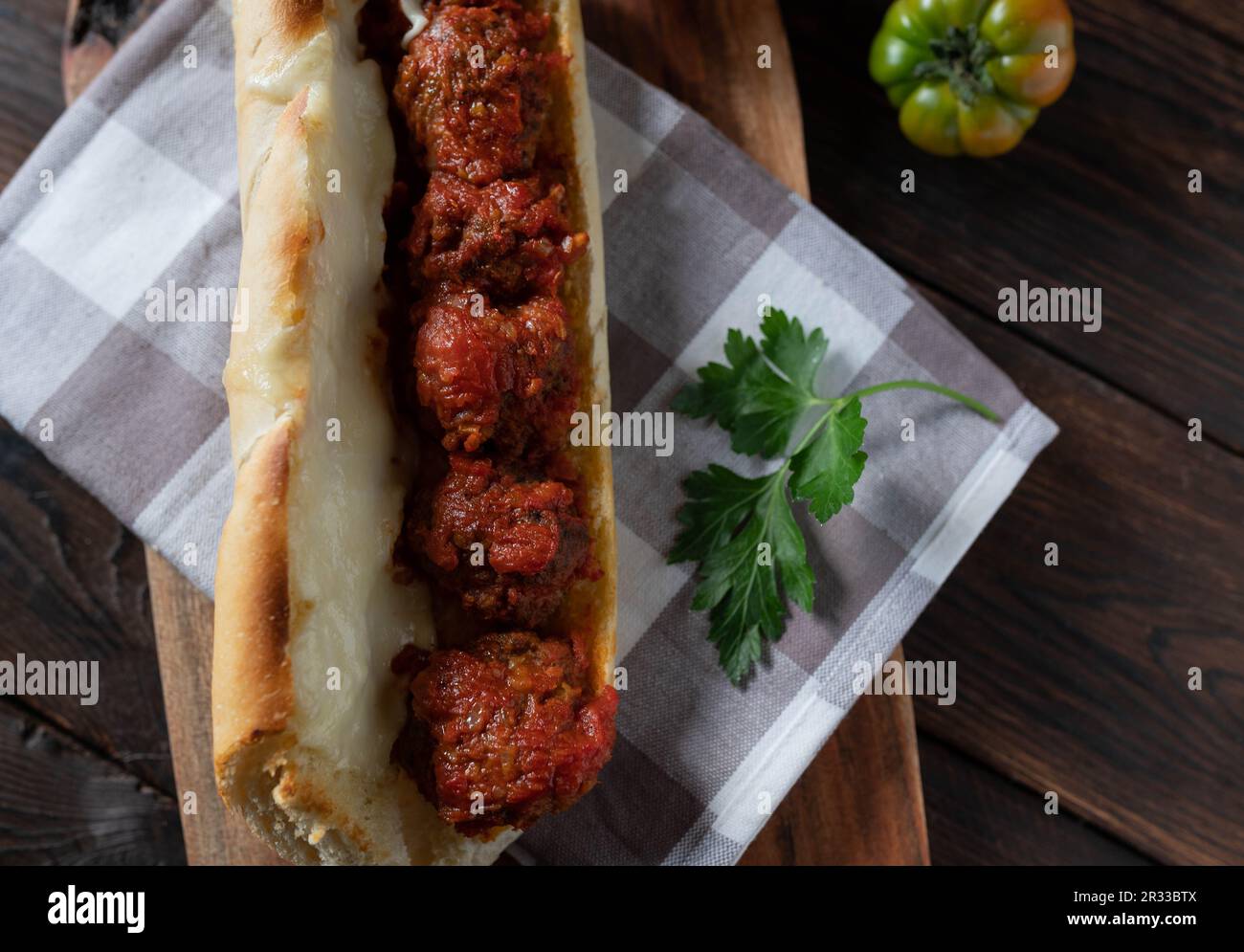 Sandwich meatball avec sauce tomate et fromage mozzarella fondu sur table en bois. Banque D'Images
