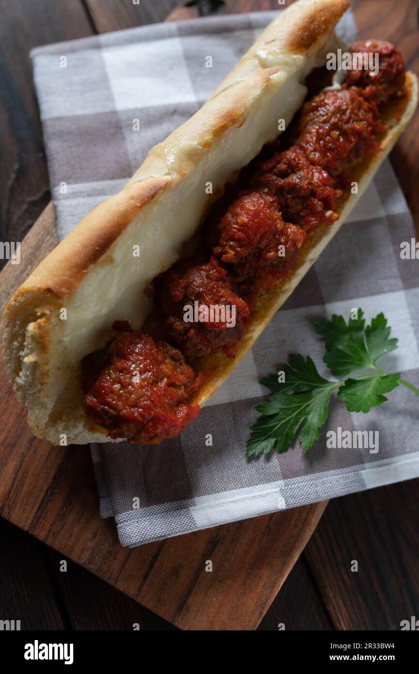 Sandwich meatball avec sauce tomate et fromage mozzarella fondu sur table en bois. Banque D'Images