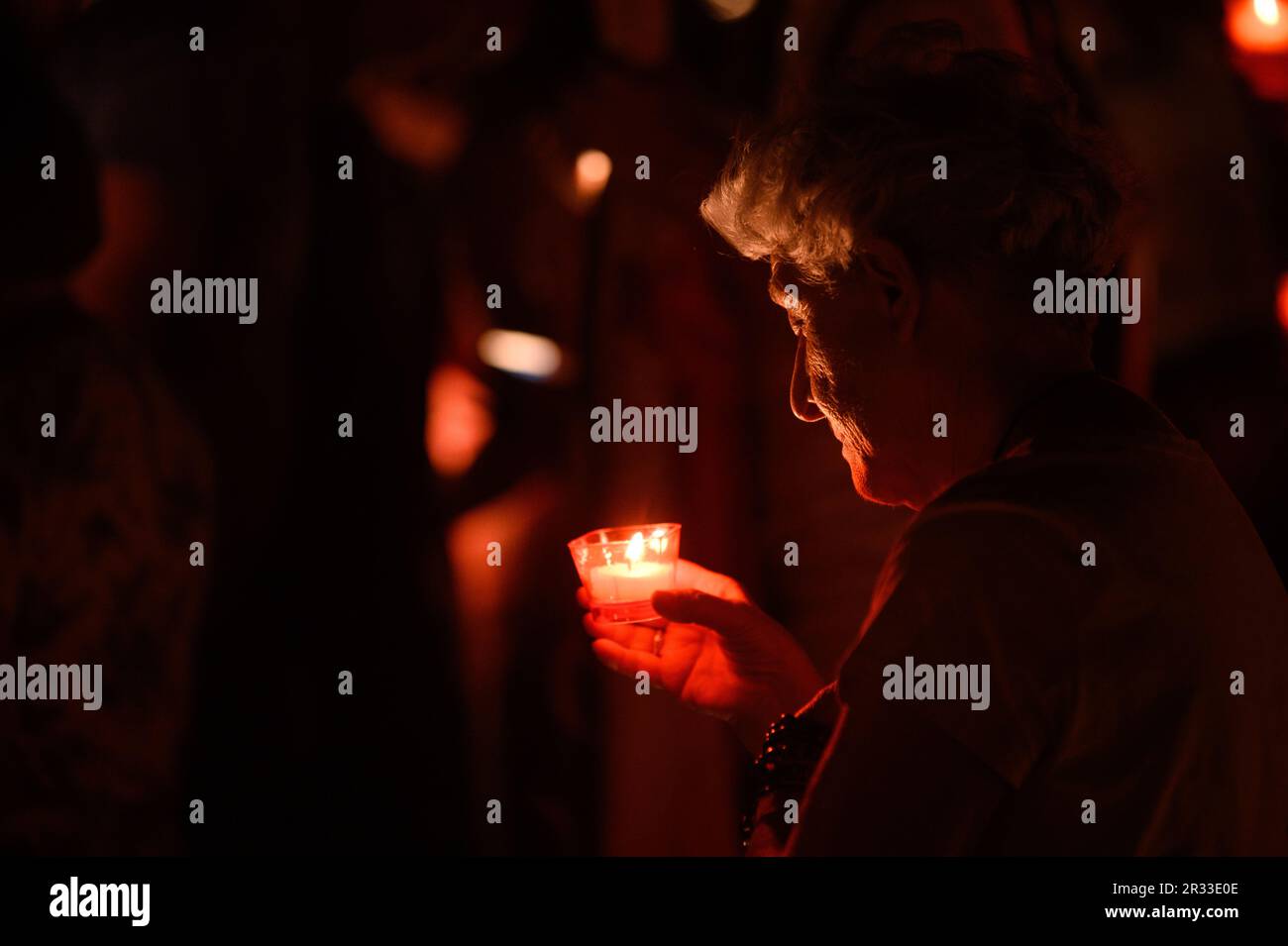 Une vieille femme tenant une bougie pendant la vénération de la Sainte Croix après la Messe pendant Mladifest (Festival de la Jeunesse) à Medjugorje. Banque D'Images