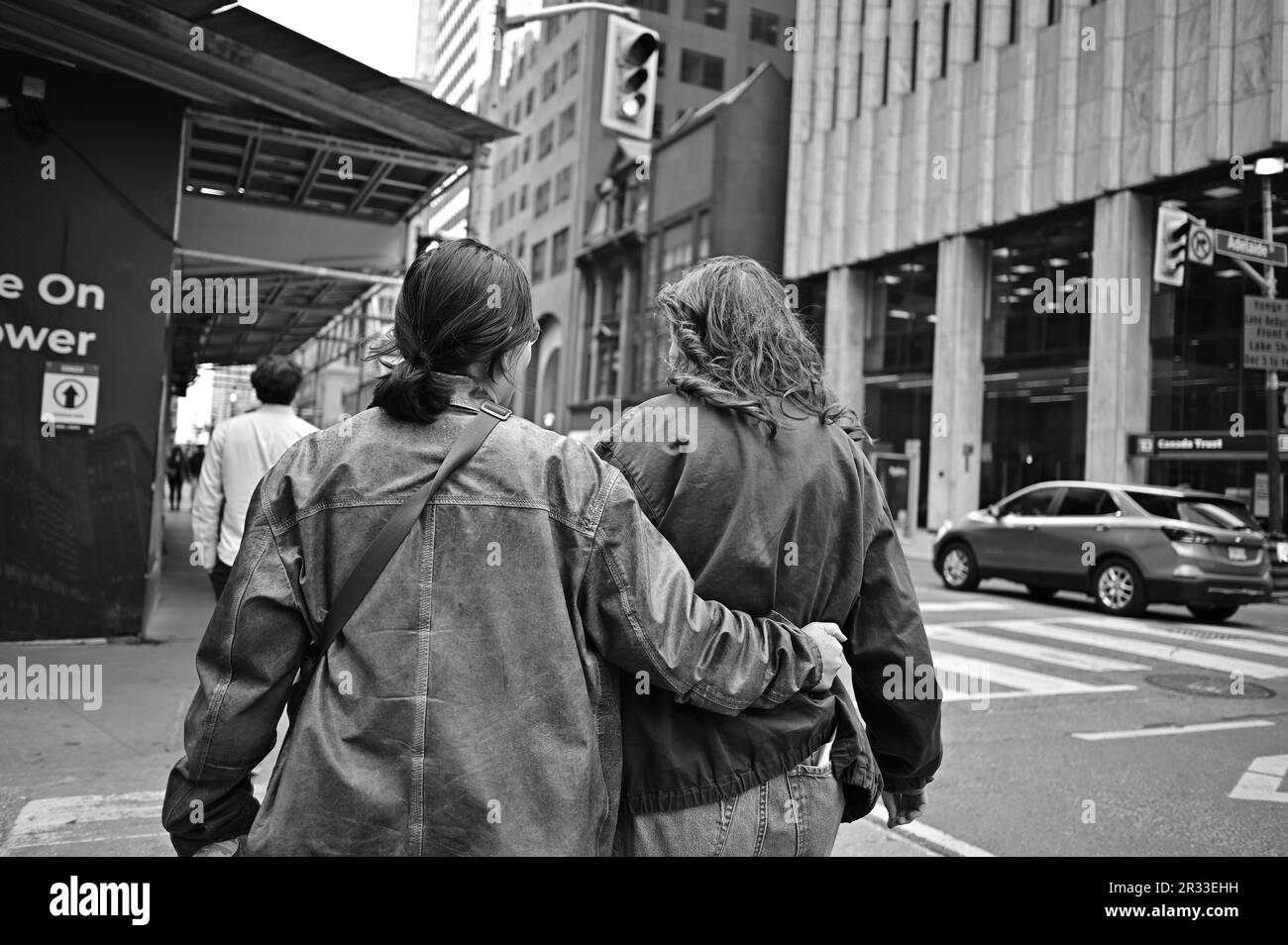 Noir et blanc : deux femmes gays marchent à Toronto ; une main est à la taille de l'autre femme Banque D'Images
