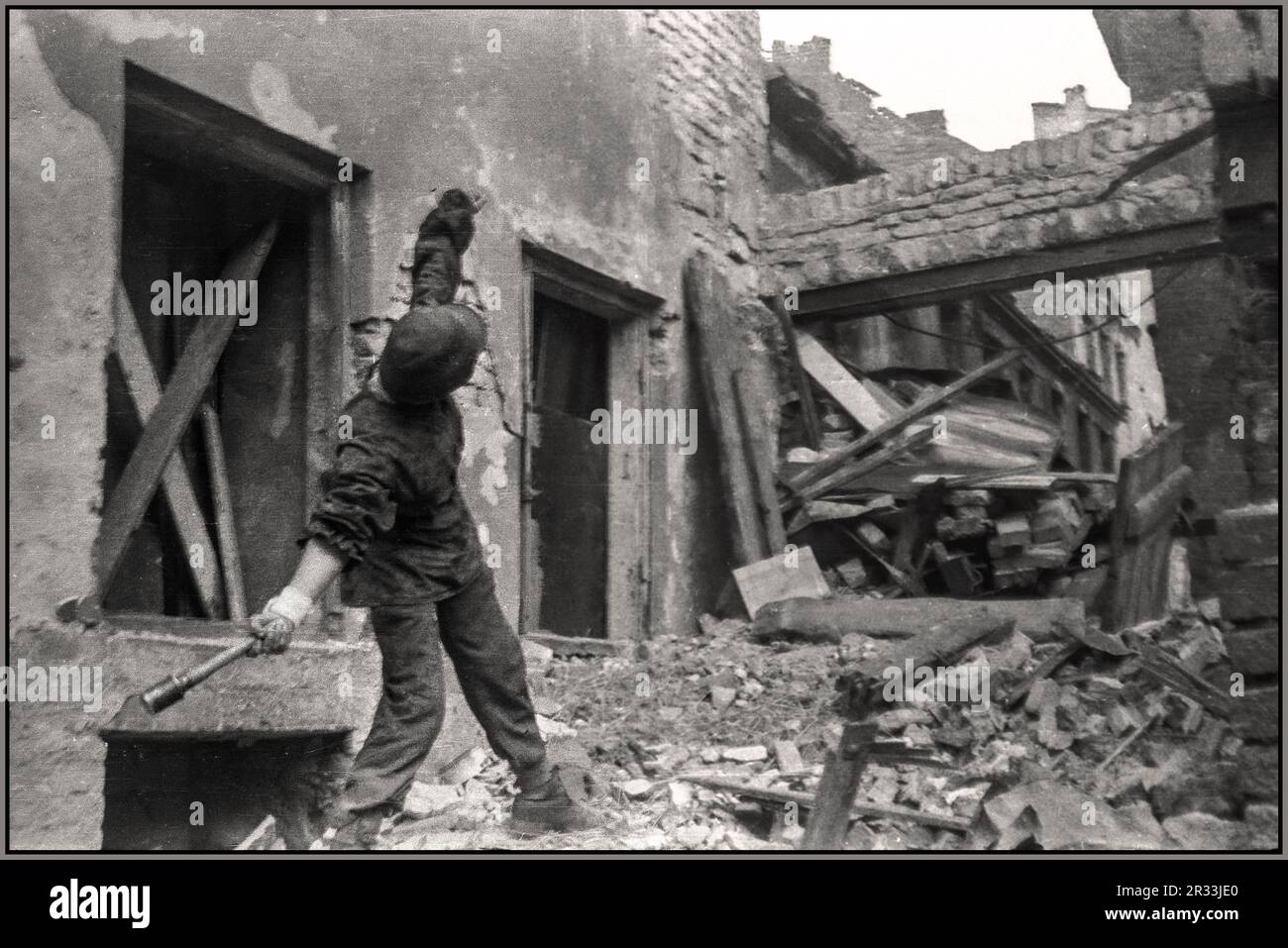 RÉSISTANCE POLONAISE WW2 révolte de Varsovie: 1945 Jerzy Siwiec 'Jur' de la compagnie 'Anna' de batallion 'Gustaw' en face de la maison de ville sur la rue Ślepa dans la vieille ville, lance une grenade Stielhandgranate-24 main sur le 'but' vers l'Allemagne nazie Wehrmacht et SS occupant des positions sur la place du château royal. Varsovie Pologne Seconde Guerre mondiale Banque D'Images