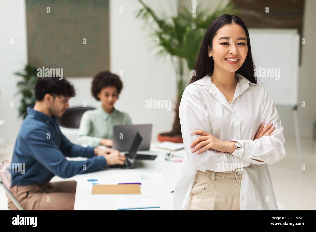 Femme d'affaires coréenne souriant debout lors d'une réunion d'entreprise dans un bureau moderne Banque D'Images