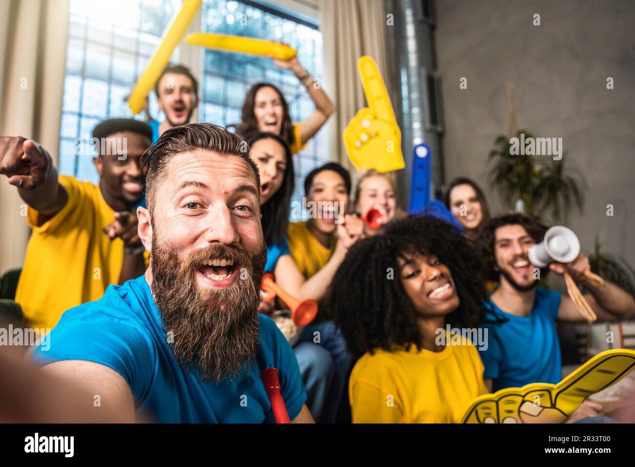 Un heureux supporter qui prend le selfie avec des fans de sport joyeux et multiethniques tout en regardant un match à la télévision à la maison - des amis célébrant la victoire quand l'équipe de sport gagne Banque D'Images