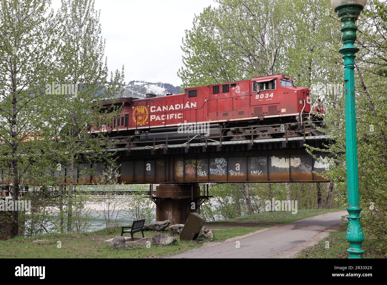 La locomotive du CP Railway traverse un pont fluvial. Montagnes en arrière-plan Banque D'Images