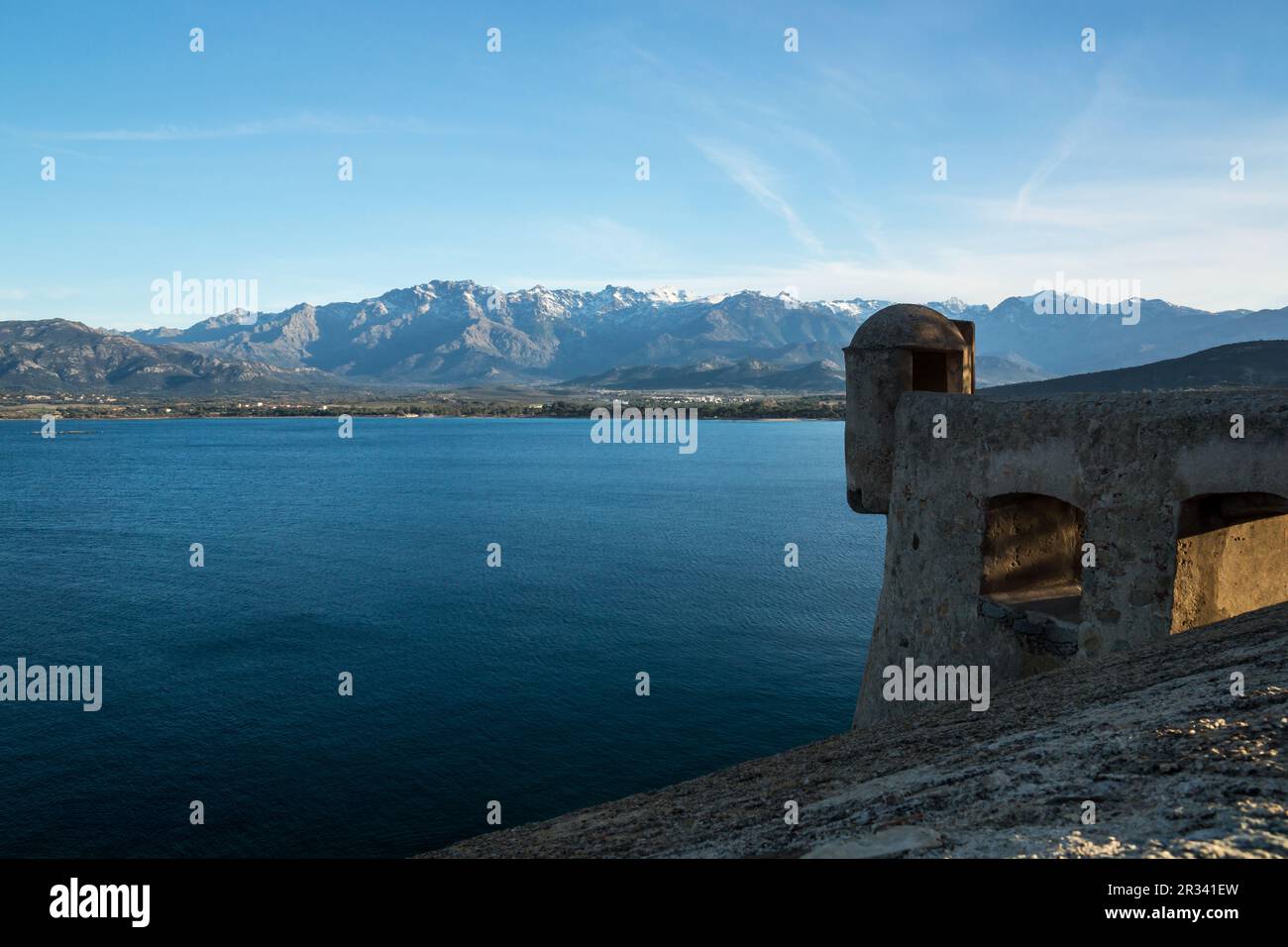 Vue sur la mer Corse depuis la citadelle de Calvi sur les montagnes enneigées. Banque D'Images