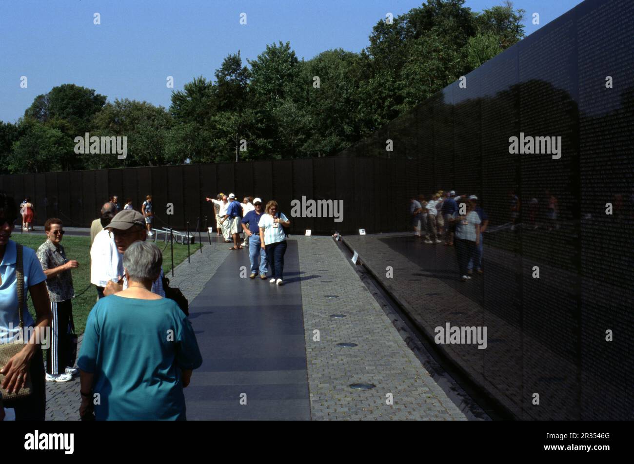 Mémorial des anciens combattants du Vietnam, Washington, D.C. ÉTATS-UNIS 9/2006. Le mémorial est composé de deux murs adjacents. Chaque mur mesure 246 pieds 9 pouces (75,21 m) de long et est composé de 72 panneaux de granit noir qui sont polis à une finition élevée. Soixante-dix des panneaux de chaque mur sont inscrits avec les noms des hommes et des femmes honorés. Les parois s'effile de 8 pouces (200 mm) de haut à leurs extrémités à 10,1 pieds (3,1 m) de haut à l'apex où elles se rencontrent, leurs bords inférieurs descendant sous le niveau de la terre environnante tandis que leurs bords supérieurs restent à niveau. Banque D'Images